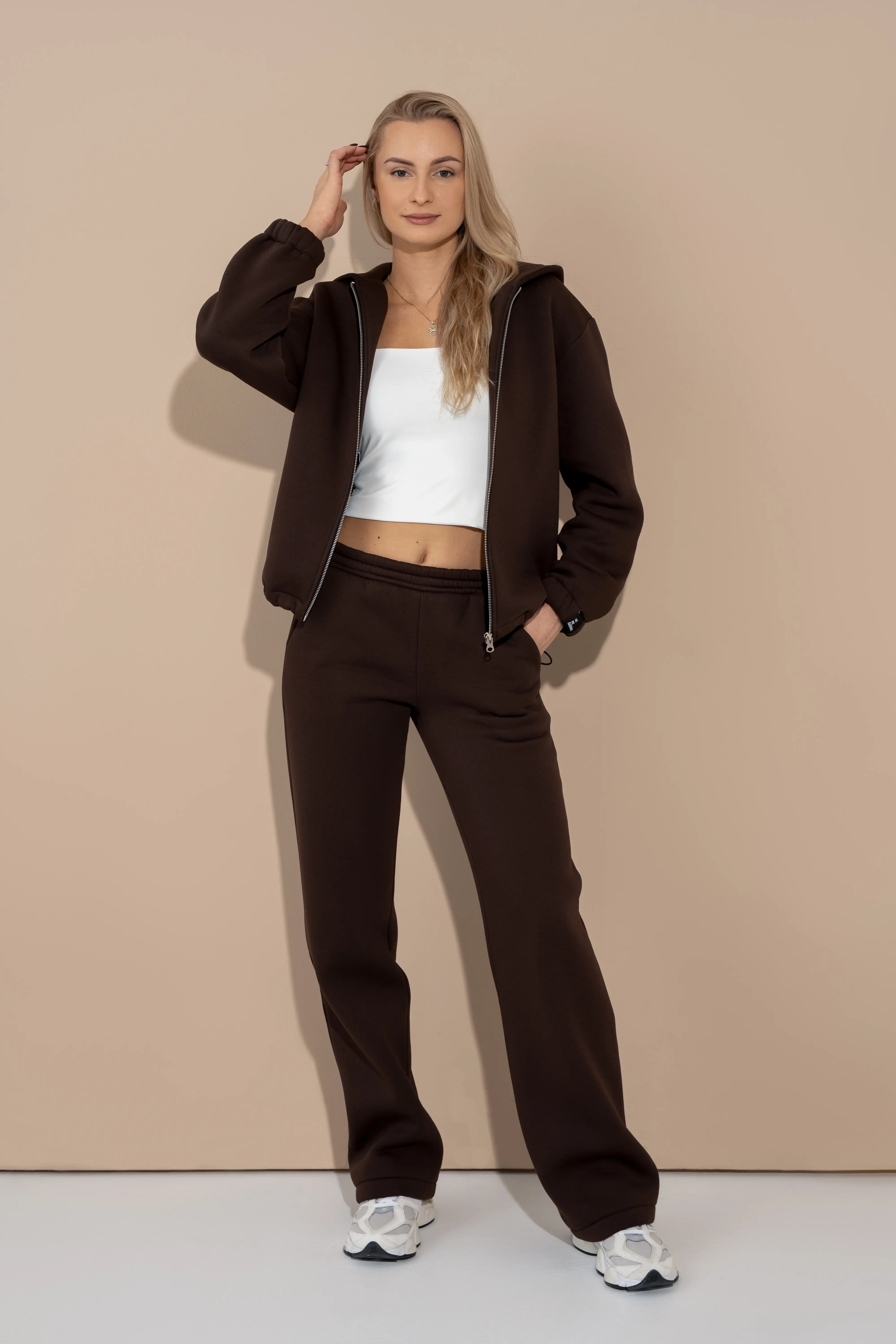 Rudos spalvos moteriškas laisvalaikio treningas su gobtuvu, metaliniu pilno ilgio užtrauktuku ir tiesiomis kelnėmis su guma ties juosmeniu