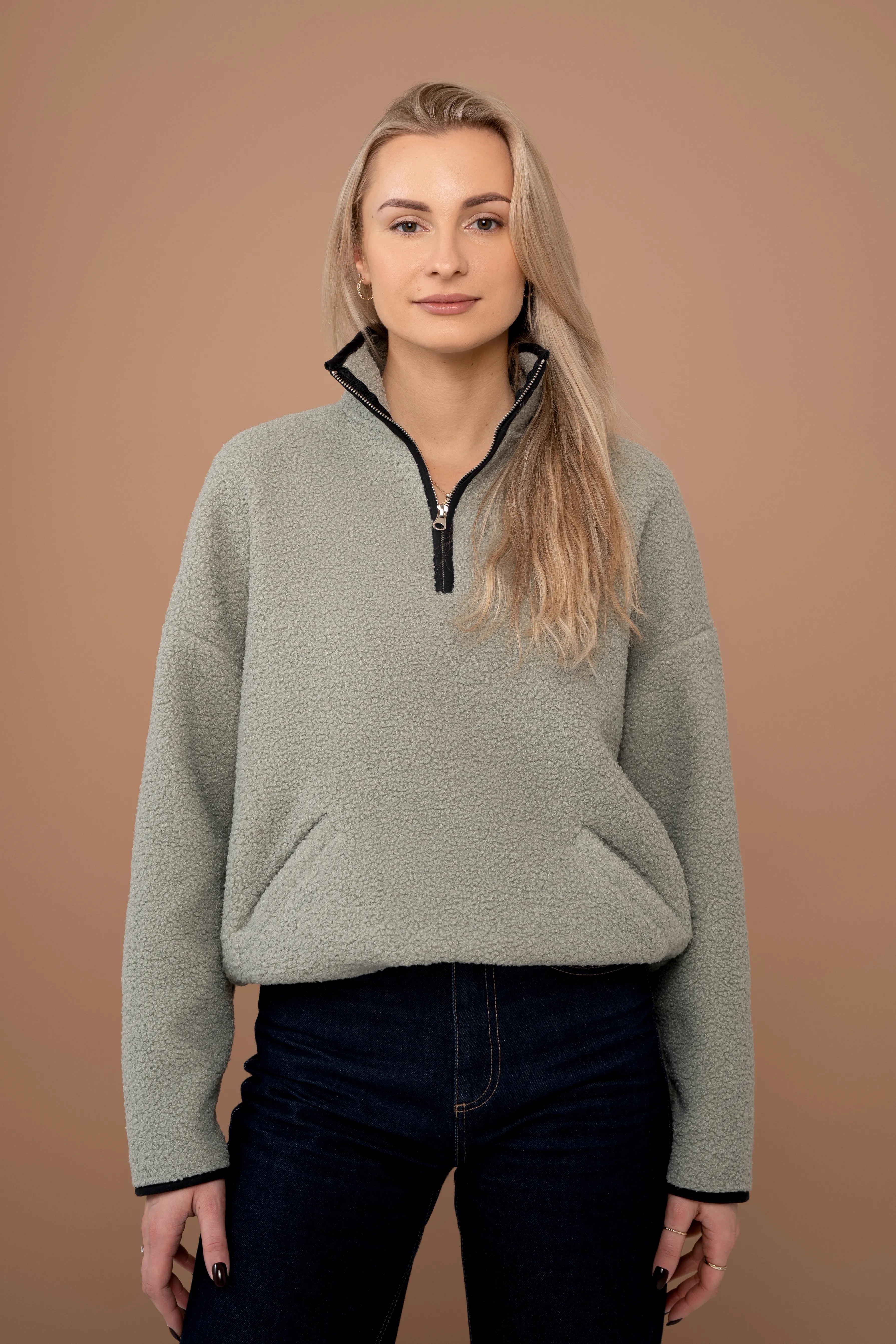 Chaki spalvos moteriškas džemperis su trumpu užtrauktuku, stačia apykakle, ilgomis rankovėmis ir vaizdu iš priekio