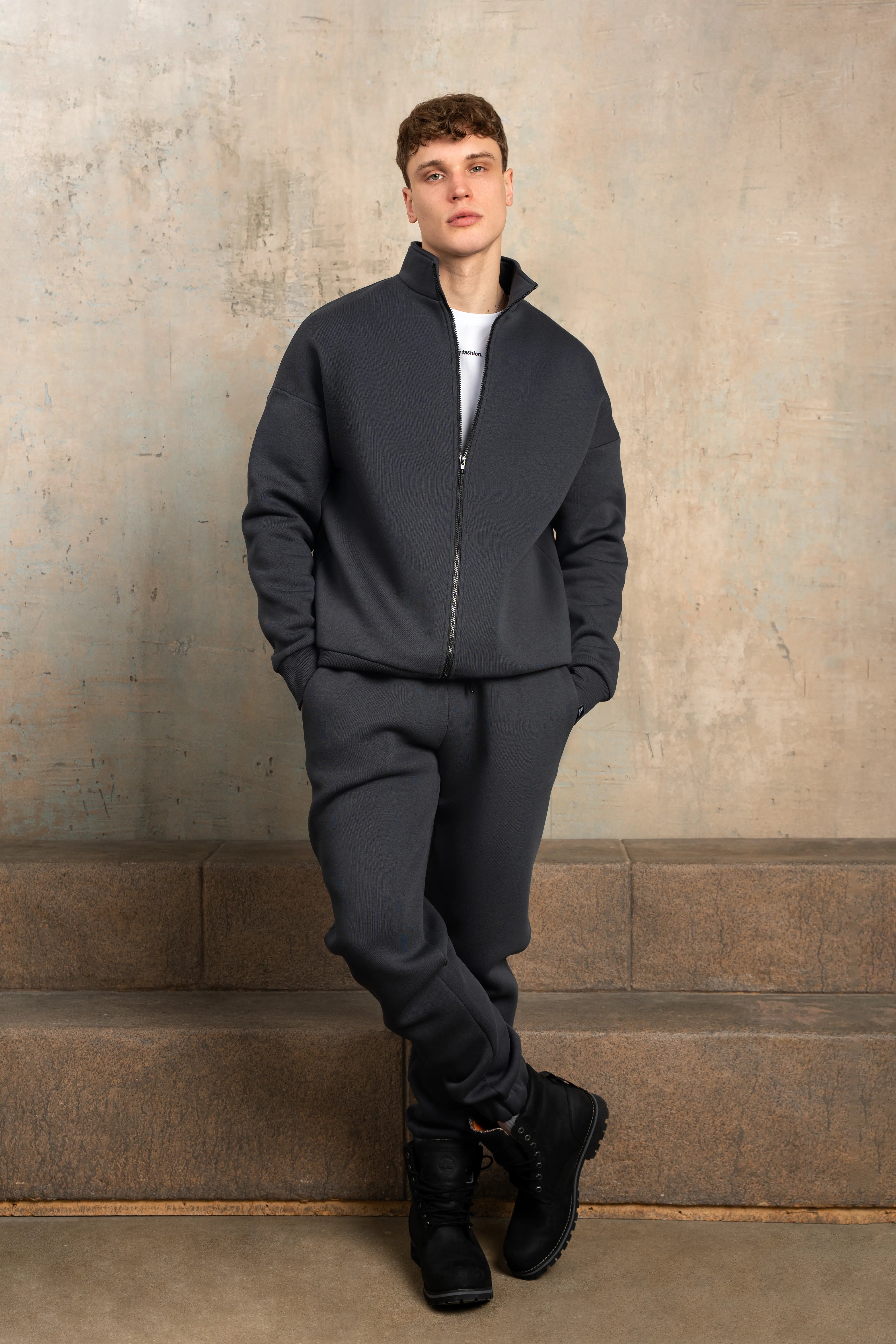 Tamsiai pilkas laisvalaikio treningas aukštu kaklu su užtrauktuku, patogus kasdienai ir poilsiui.