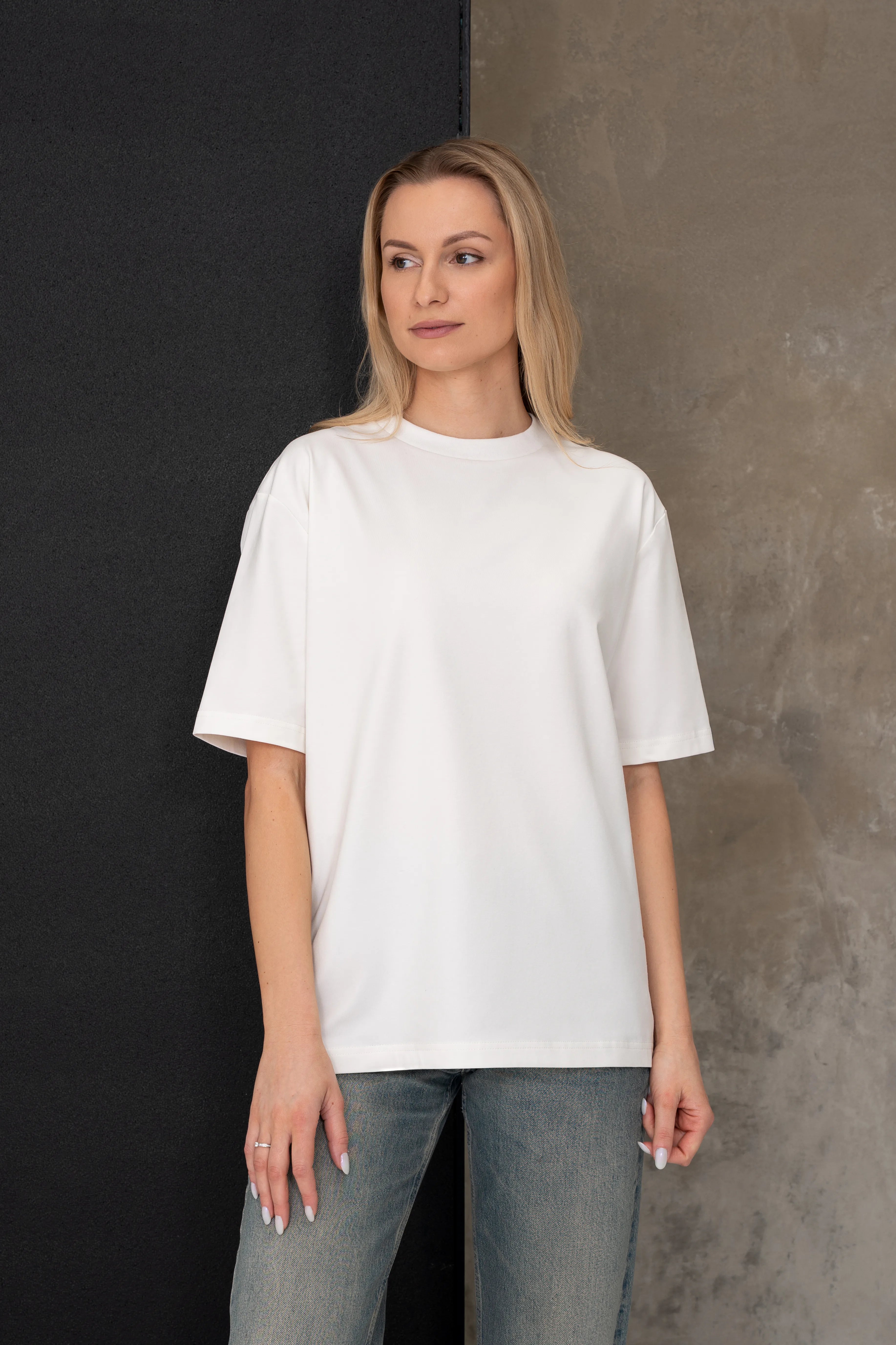 Moteriški laisvalaikio marškinėliai pieno baltumo spalvos, oversized modelis iš priekio