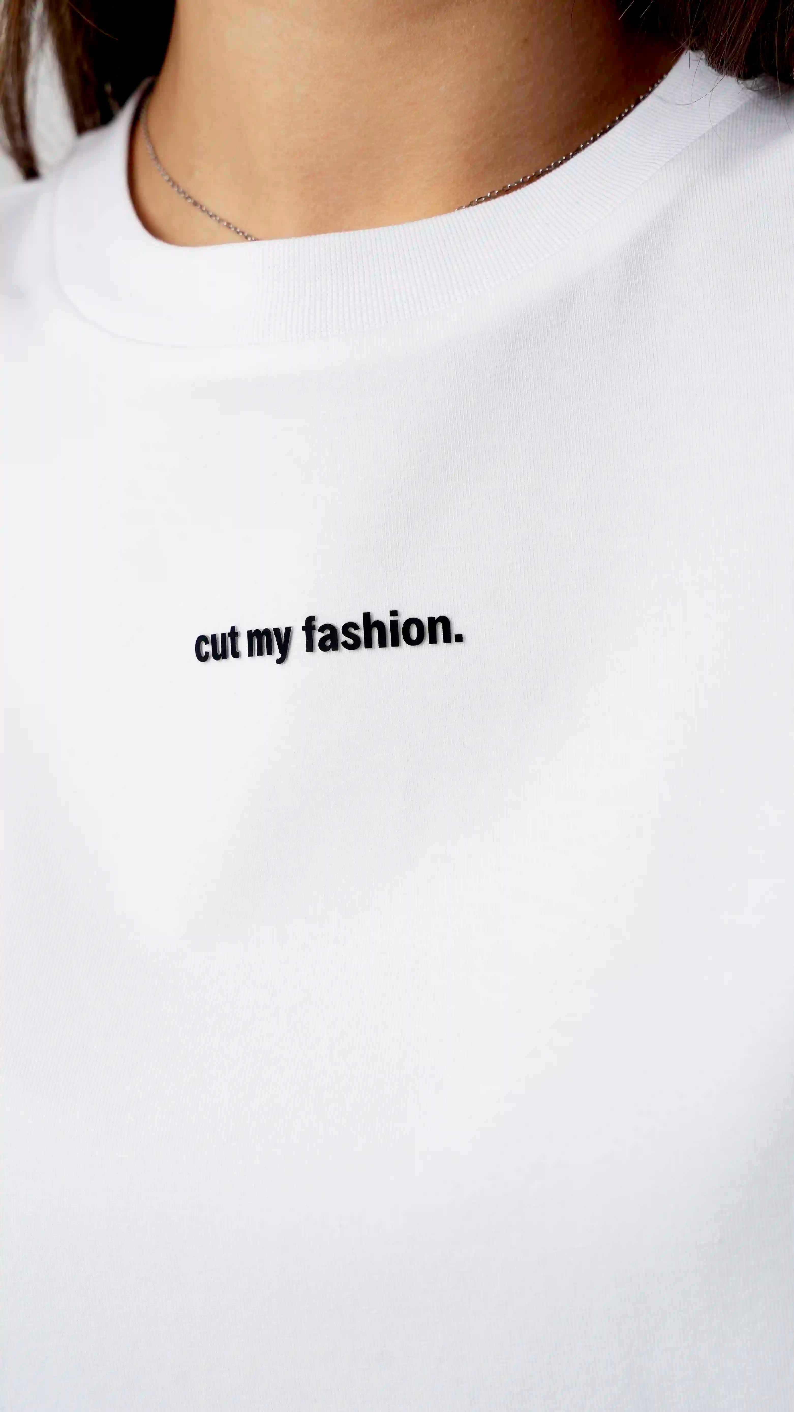 Balti oversized moteriški marškinėliai su „cutmyfashion“ logotipu ant krūtinės, pralaidūs orui, pagaminti iš 90% medvilnės ir 10% poliesterio.