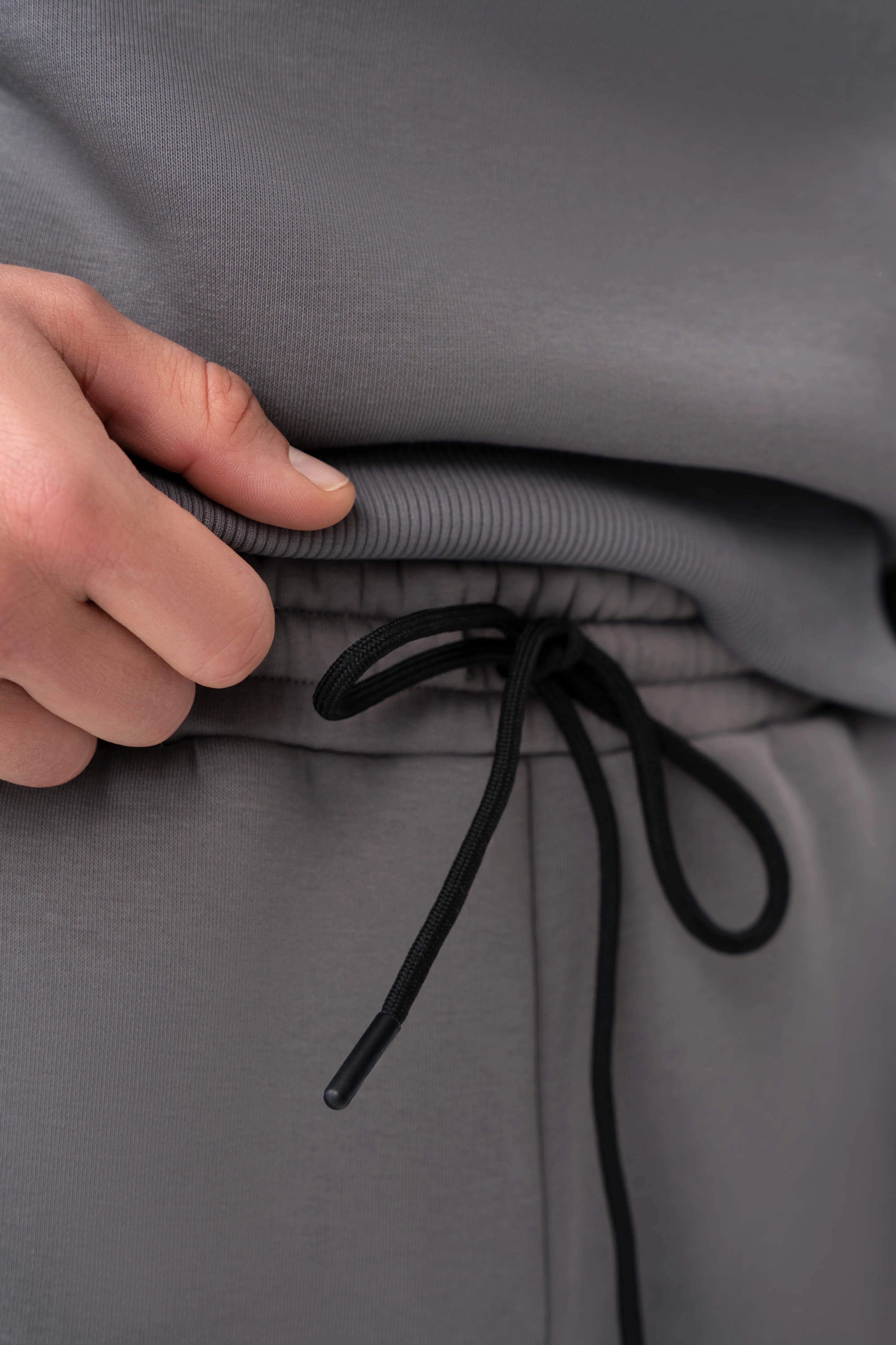 Minkšto trikotažo vyriškas pilkas treningas su aukšta apykakle, patogus dėvėti kelionėse ar savaitgalio poilsiui.