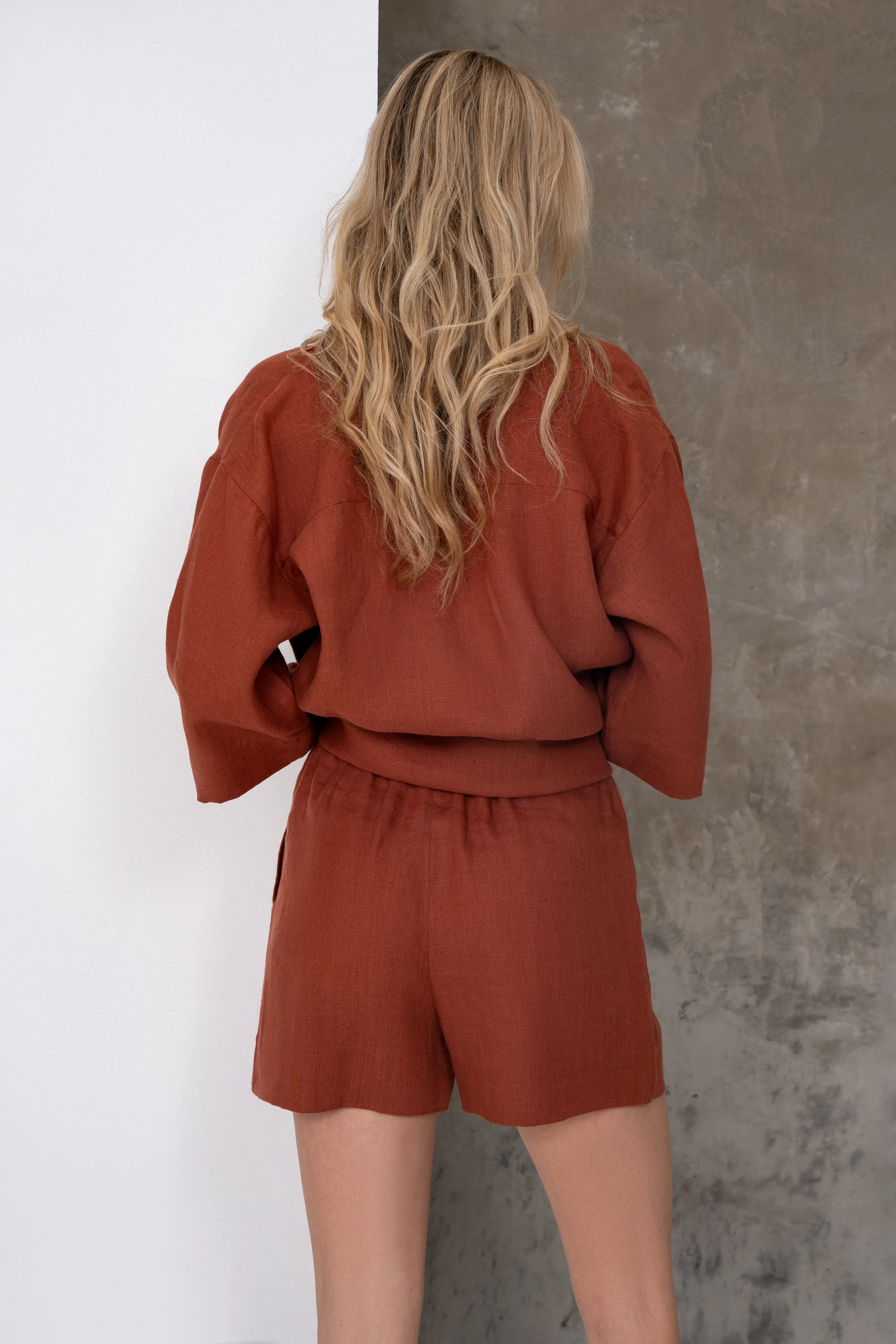 Damen-Leinenshorts in Ziegelrot, Rückansicht mit einem locker sitzenden T-Shirt