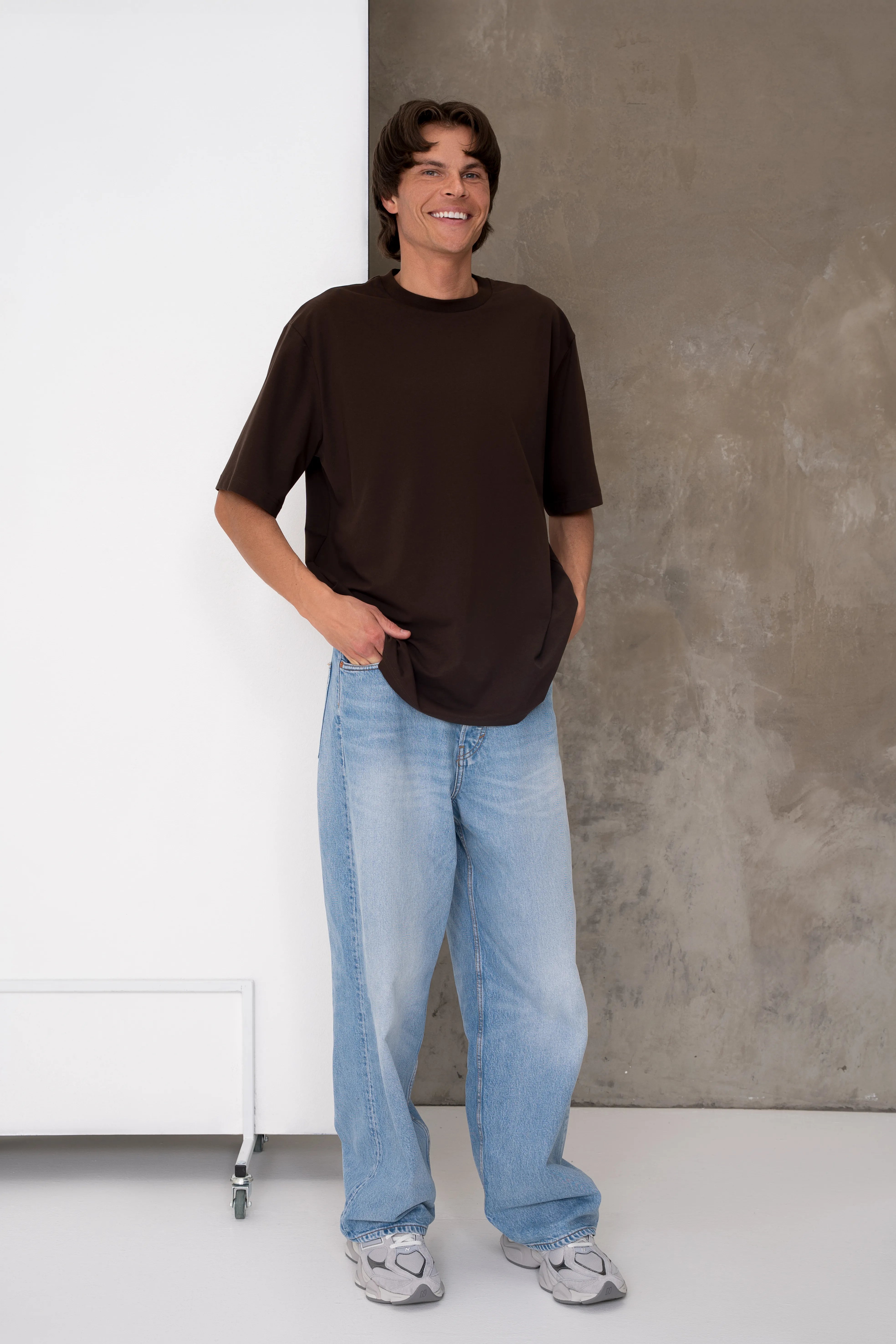 Rudi vyriški oversized marškinėliai trumpomis rankovėmis su apvalia kaklo iškirpte, laisvu siluetu ir juoda cutmyfashion etikete ant rankovės, vidutinis vaizdas iš priekio